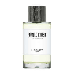 Heeley - Pomelo Crush Parfumflakon mit schlichtem weißen Etikett und schwarzem Holzdeckel auf weißem Hintergrund