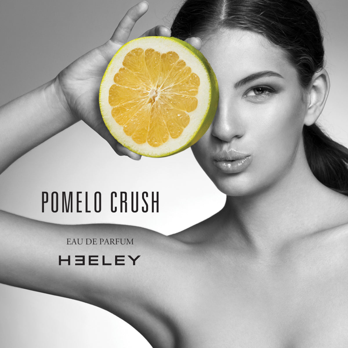 Heeley - Pomelo Crush Werbefoto mit Frau, die eine aufgeschnittene Pampelmuse vor ihr Auge hält