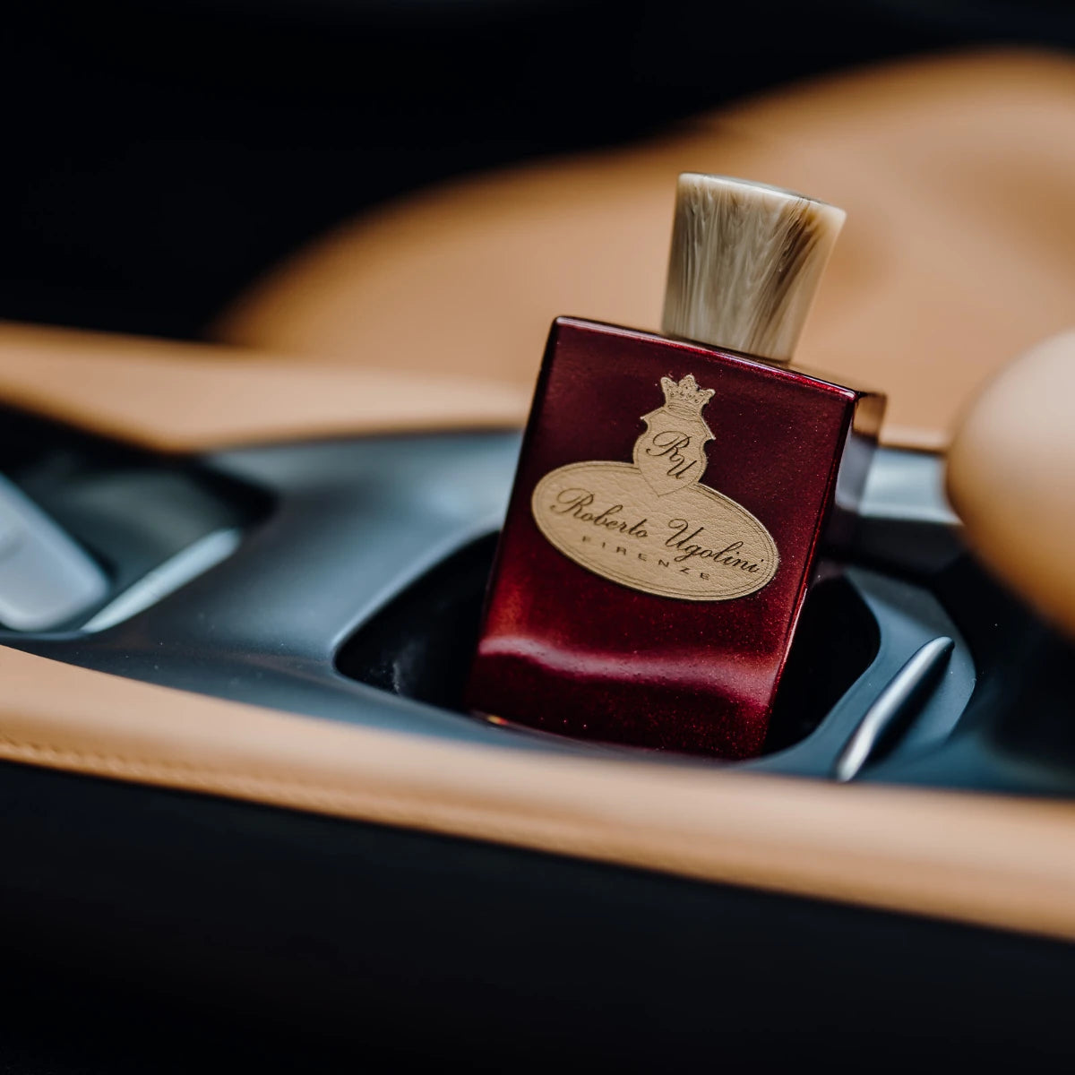 Roberto Ugolini - 4 Rosso edler roter Flakon mit goldfarbenem Wappen in luxuriösem Autointerieur platziert