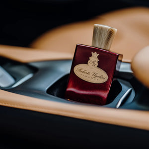 Roberto Ugolini - 4 Rosso edler roter Flakon mit goldfarbenem Wappen in luxuriösem Autointerieur platziert