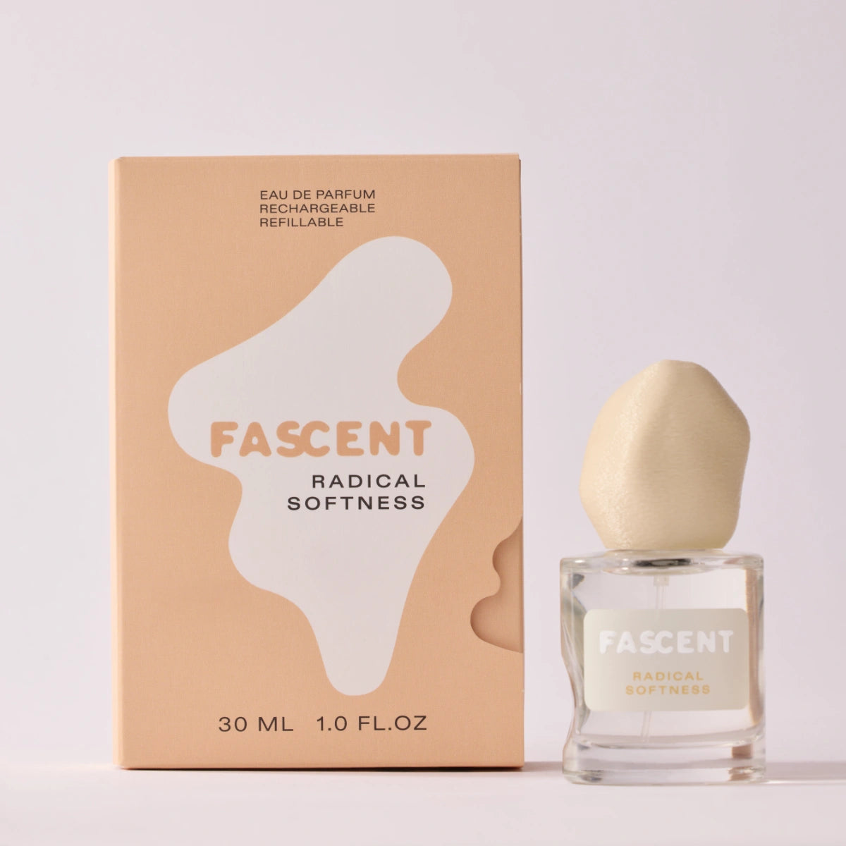 Fascent - Radical Softness Parfumflakon mit organisch geformtem, hellbeigem Deckel neben pastellfarbener Verpackung