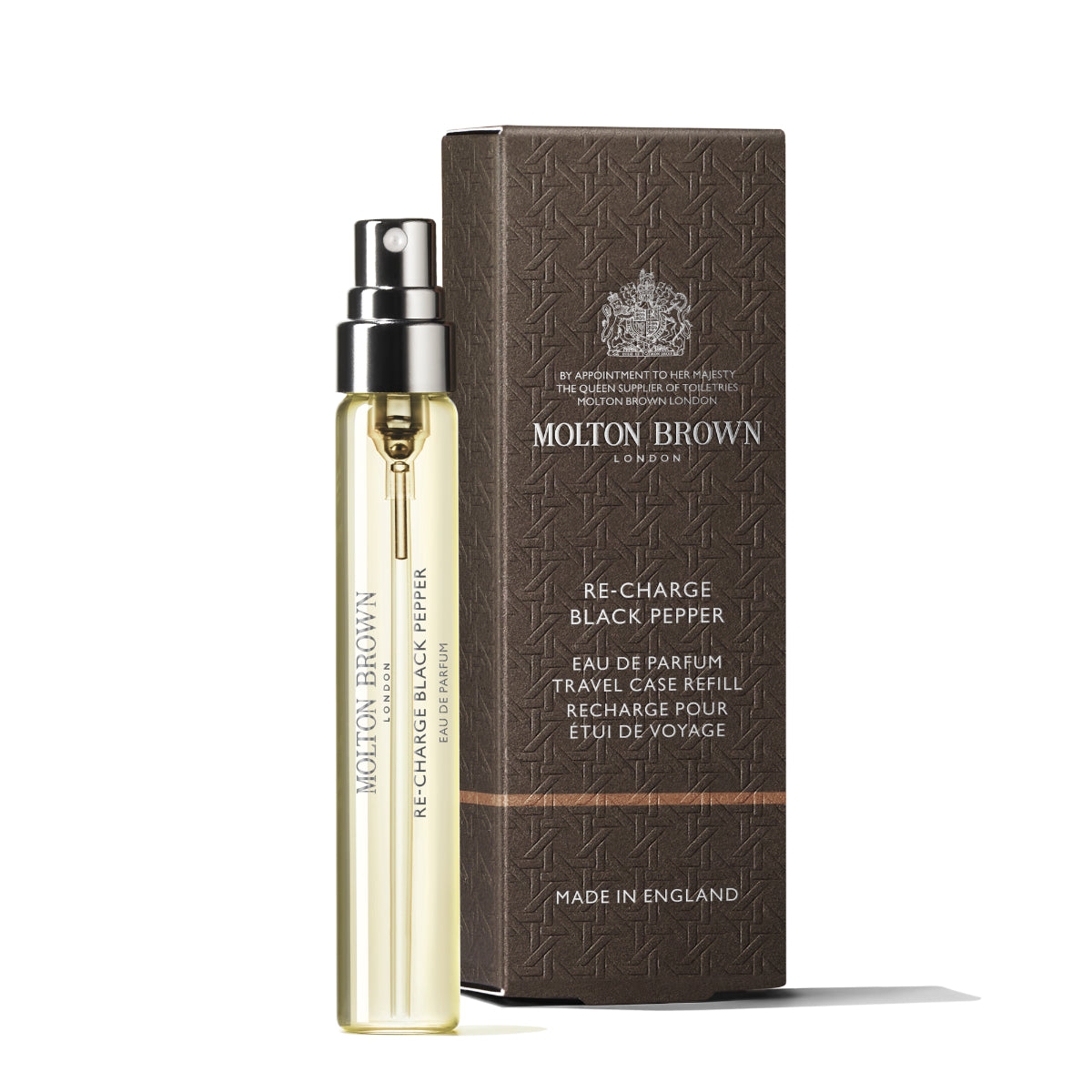 Molton Brown - Re-Charge Black Pepper Reisezerstäuber mit transparentem Gelb und silbernem Sprühkopf neben brauner Verpackung