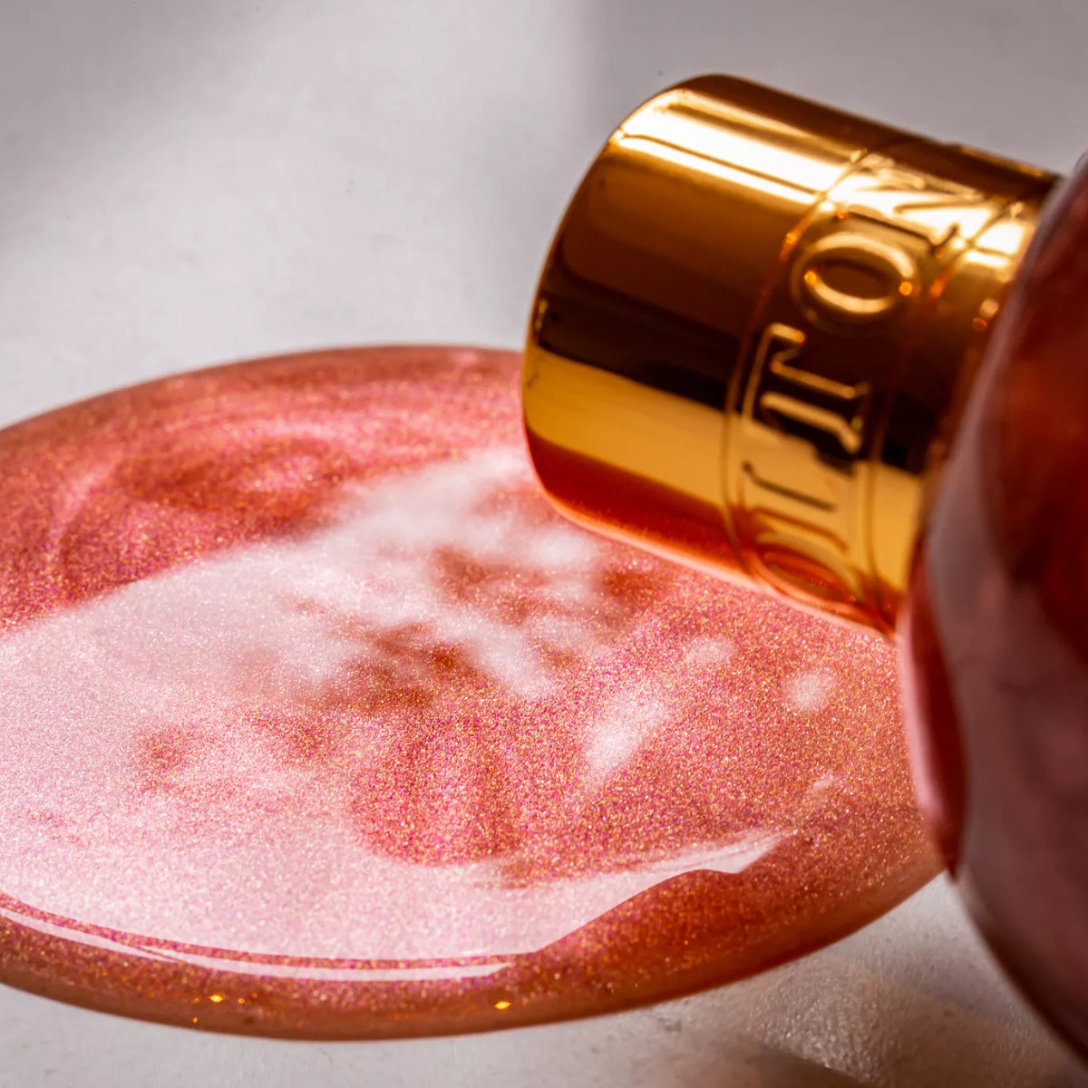 Molton Brown - Rose Dunes - Bath & Shower Gel mit schimmerndem rosa Duschgel und goldfarbenem Verschluss auf hellem Untergrund