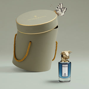 Penhaligon's - Portraits - The Blazing Mister Sam Flakon mit goldenem Stierkopf vor edler Geschenkbox und Schmetterling