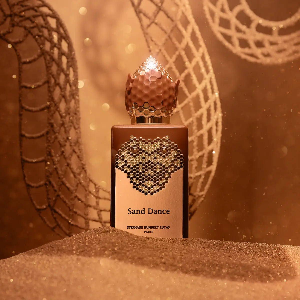 Stéphane Humbert Lucas 777 - Sand Dance Parfumflakon mit honigfarbenem Design und goldener Wabenverzierung in warmer Ambiente