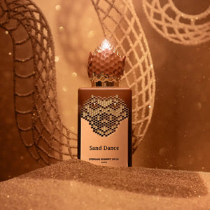Stéphane Humbert Lucas 777 - Sand Dance Parfumflakon mit honigfarbenem Design und goldener Wabenverzierung in warmer Ambiente