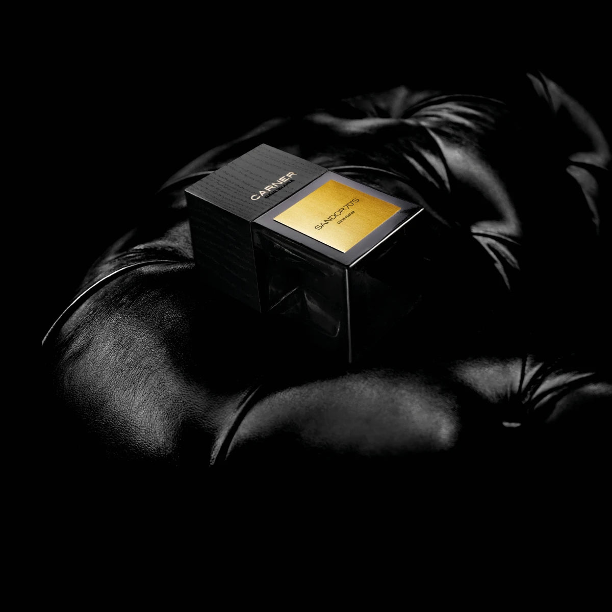 Carner Barcelona - Black Collection - Sandor 70's Parfumflakon mit goldfarbenem Etikett auf schwarzem Lederhintergrund