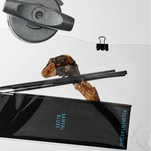 Pigmentarium - Räucherstäbchen - Santal Blues in schwarzer eleganter Verpackung mit drei schwarzen Stäbchen auf Holzdekoration