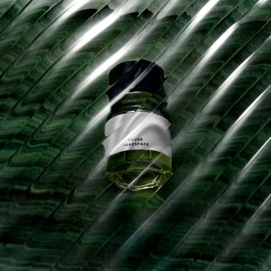 Headspace - Sauge Parfumflakon mit grünem Inhalt und minimalistischem Etikett vor dunklem, strukturiertem Hintergrund