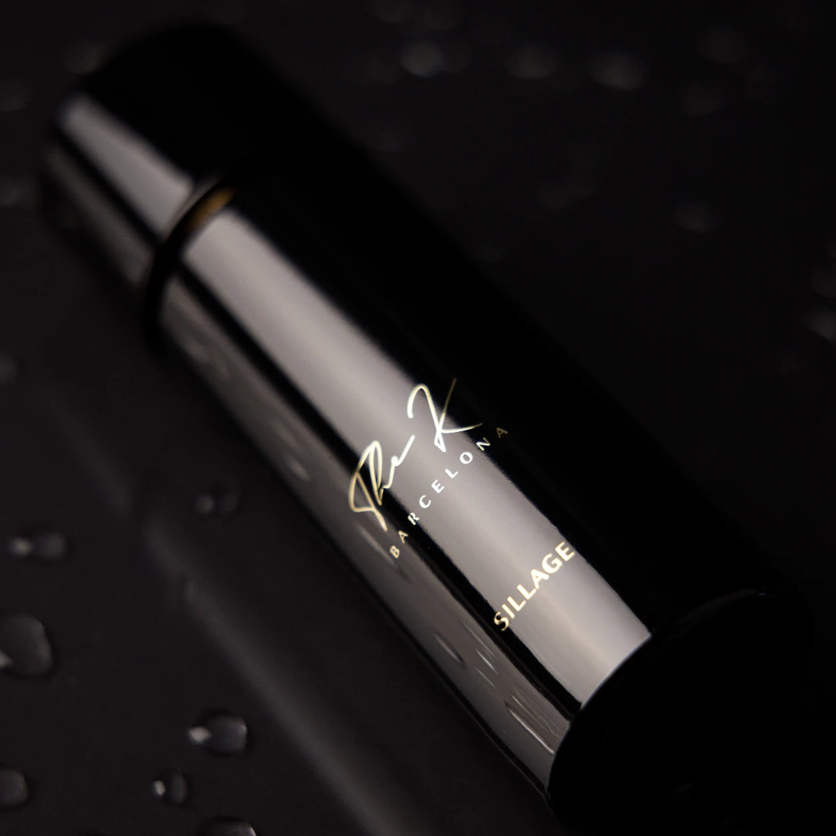 Kinetic Perfumes - Sillage Parfumflakon in glänzendem Schwarz mit minimalistischer goldener Schrift und Wassertropfen auf dunklem Hintergrund
