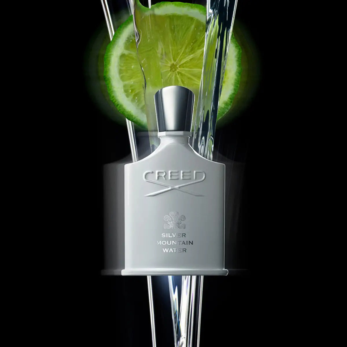 Creed - Silver Mountain Water Flakon in mattem Weiß mit silberfarbenem Verschluss vor schwarzem Hintergrund mit Limettenscheiben