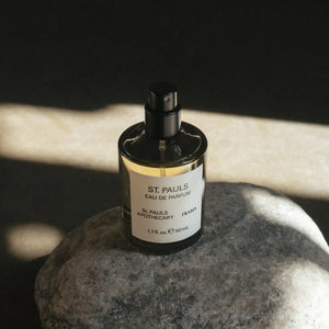 FRAMA - St. Pauls Eau de Parfum Flakon mit schwarzem Spraykopf auf grauem Stein und Schattenwurf
