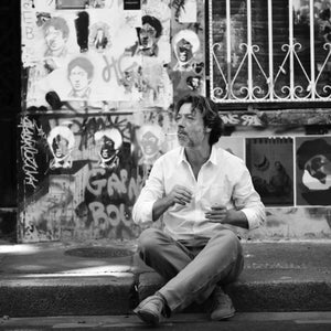 Stéphane Humbert Lucas 777 - Rose de Petra zeigt Mann in entspannter Pose vor urbaner Wand mit Streetart in Schwarzweiß