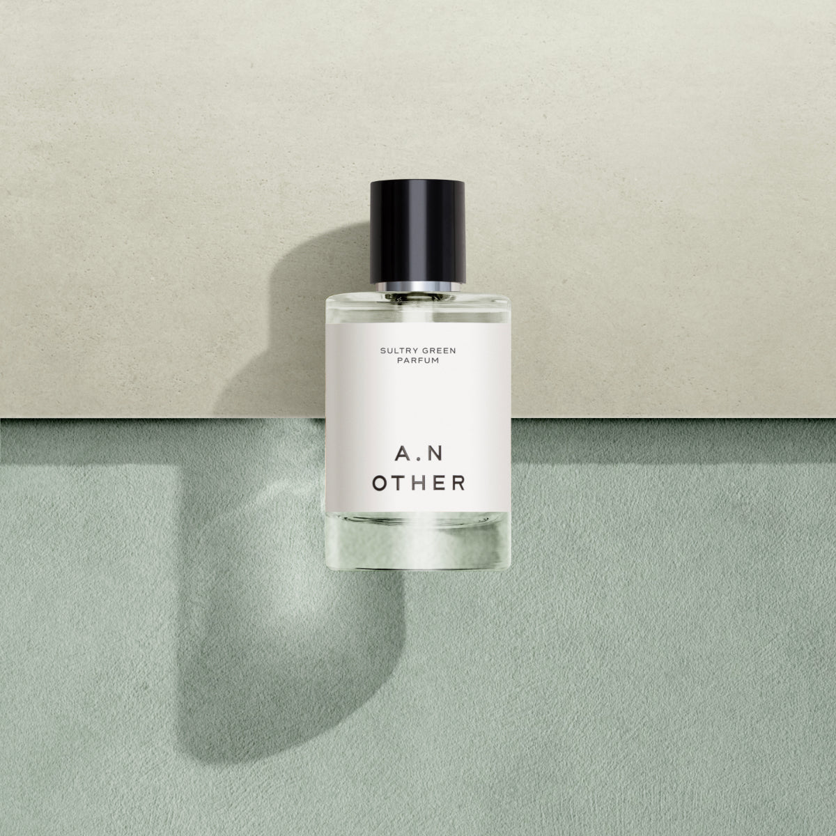 A.N. OTHER - Sultry Green Parfumflakon mit schlichtem Etikett und schwarzem Verschluss vor zweifarbigem Hintergrund