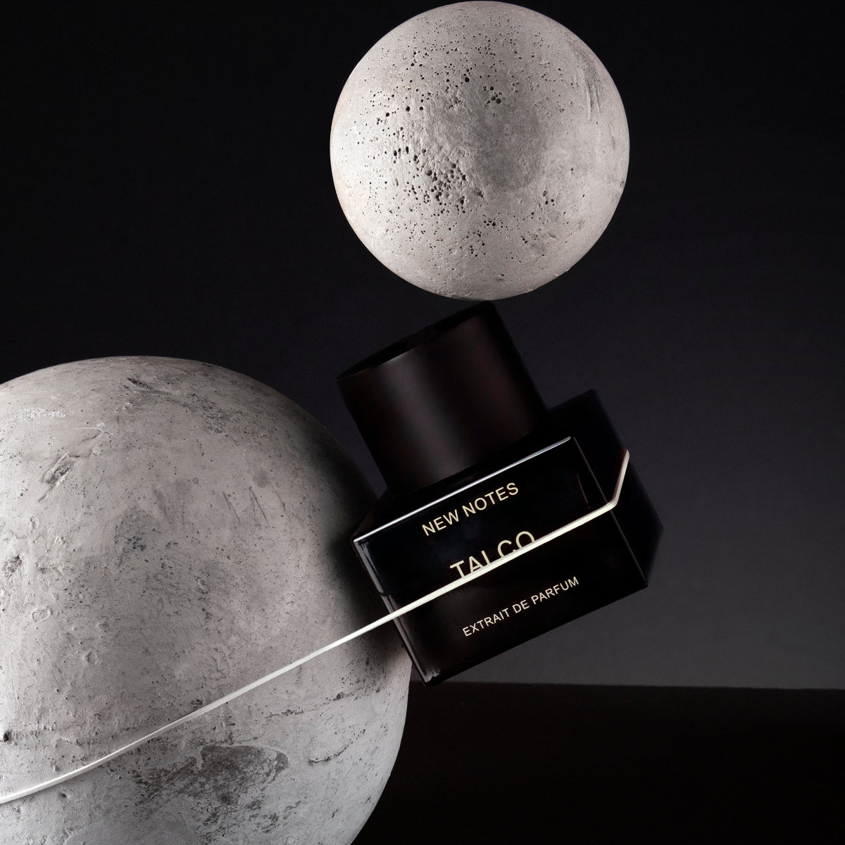 New Notes - Contemporary Blend Collection - Talco Parfumflakon in schwarzem Design vor dunklem Hintergrund mit geometrischen Dekoelementen