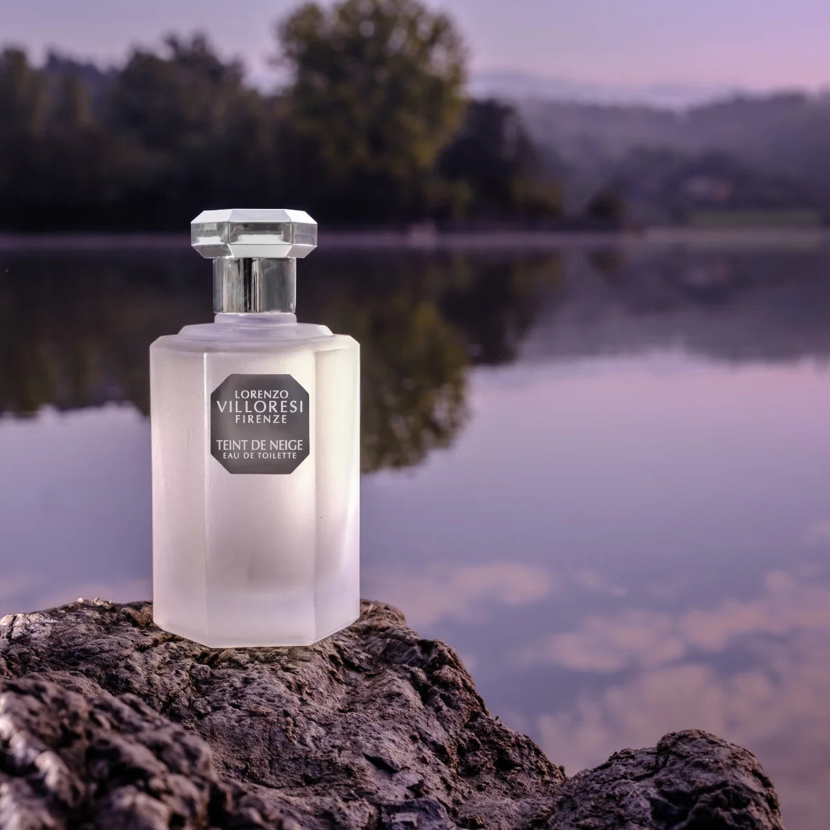 Lorenzo Villoresi Teint de Neige Eau de Toilette in frosted glass bottle with faceted clear cap by the lake at sunset