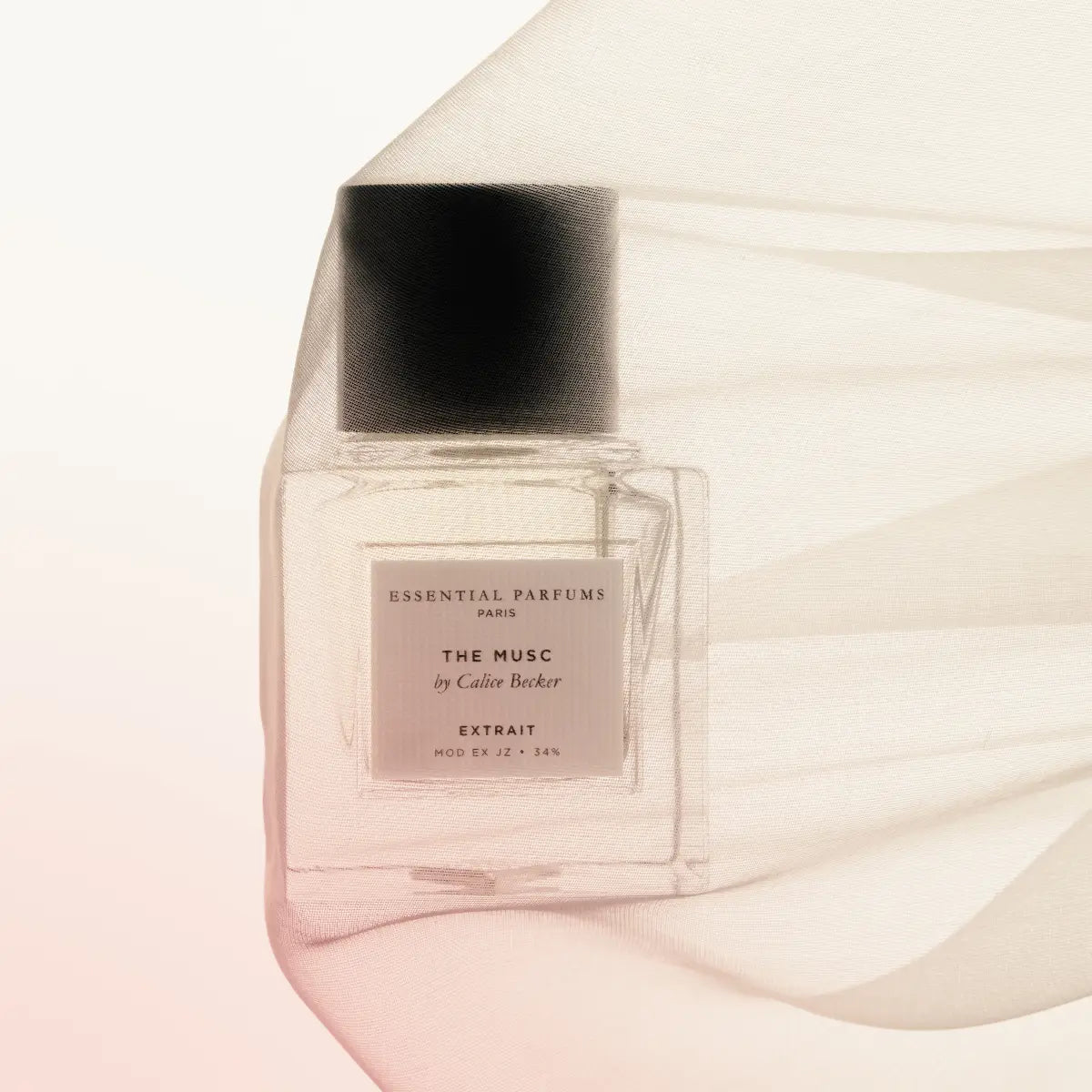 Essential Parfums - The Musc - Extrait de Parfum zeigt klaren Flakon mit schwarzem Deckel und zartem, fließendem Stoff im Hintergrund