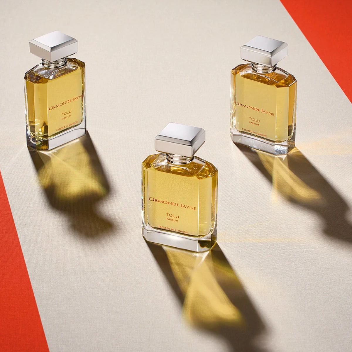 Ormonde Jayne - Tolu Parfumflakons mit klarem Glas und eckigen silbernen Verschlüssen auf hellgrund mit roter Ecke
