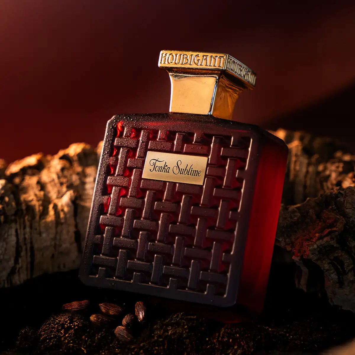 Houbigant - Collection les Ambres - Tonka Sublime Flakon mit dunkelrotem Glas und goldfarbenem Verschluss im warmen Licht