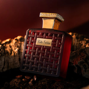 Houbigant - Collection les Ambres - Tonka Sublime Flakon mit dunkelrotem Glas und goldfarbenem Verschluss im warmen Licht