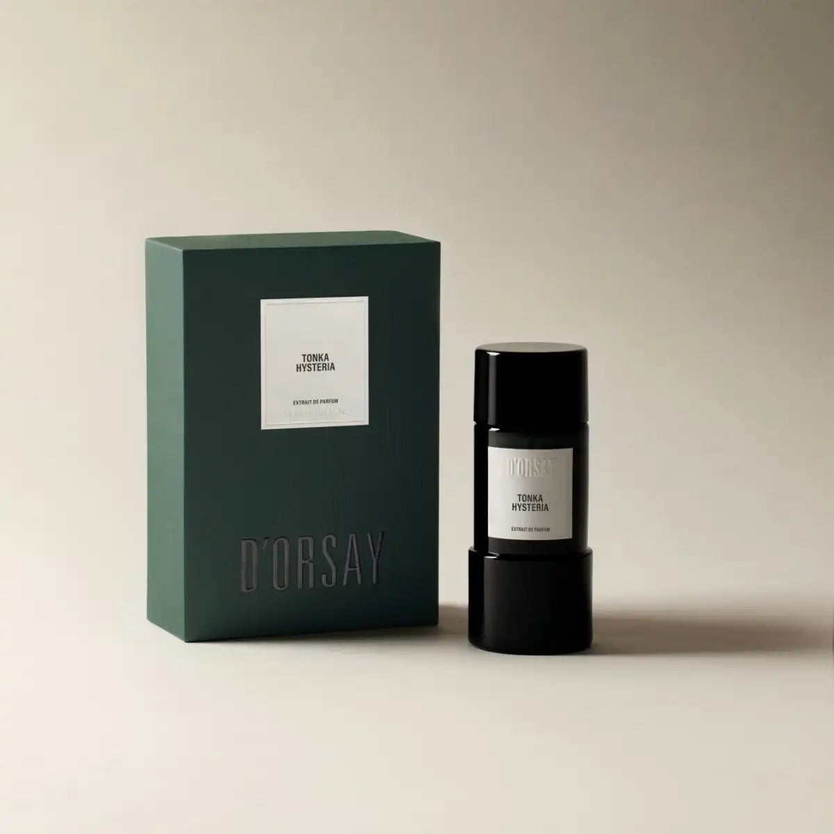 D'Orsay - Tonka Hysteria Parfüm-Extrakt in elegantem schwarzem Flakon neben grünem Verpackungskarton vor beiger Wand