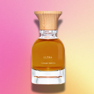 Hiram Green - Ultra Parfumflakon mit bernsteinfarbener Flüssigkeit und naturbelassenem Holzverschluss vor sanftem Farbverlauf