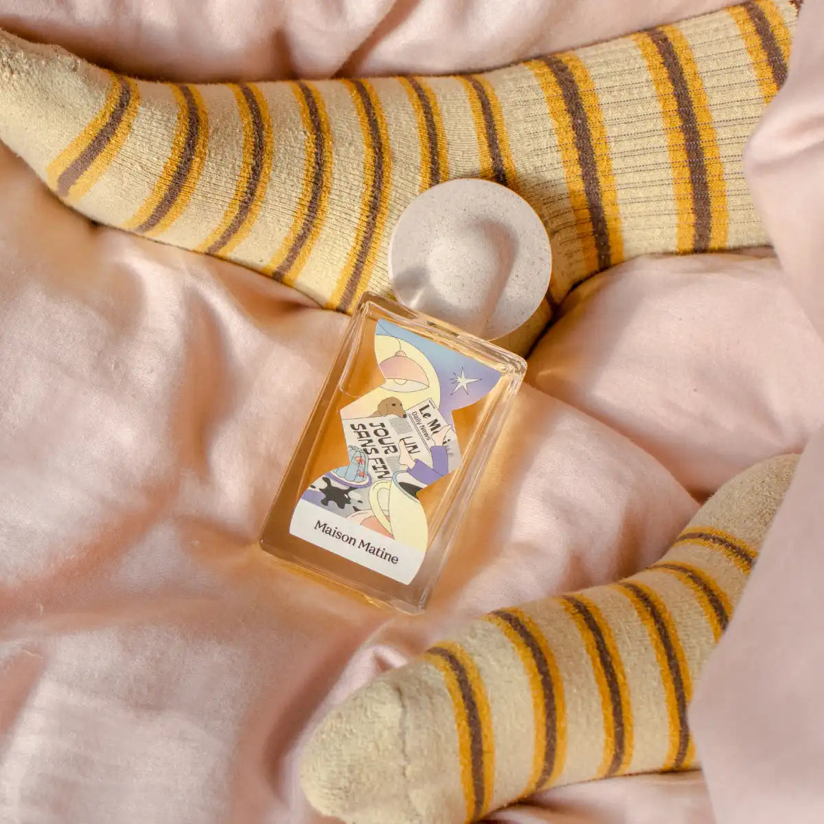 Maison Matine - Night Fever Collection - Un Jour sans Fin Flakon mit verspieltem Etikett auf zartem Stoff und gestreiften Socken
