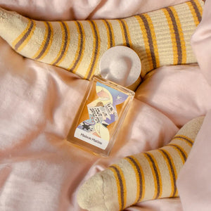 Maison Matine - Night Fever Collection - Un Jour sans Fin Flakon mit verspieltem Etikett auf zartem Stoff und gestreiften Socken