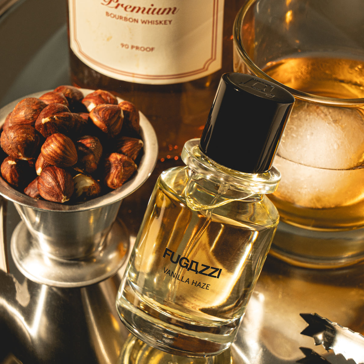 Fugazzi - Vanilla Haze Extrait Parfumflakon mit klarem Glas neben Nüssen und Whiskyglas auf Spiegeloberfläche