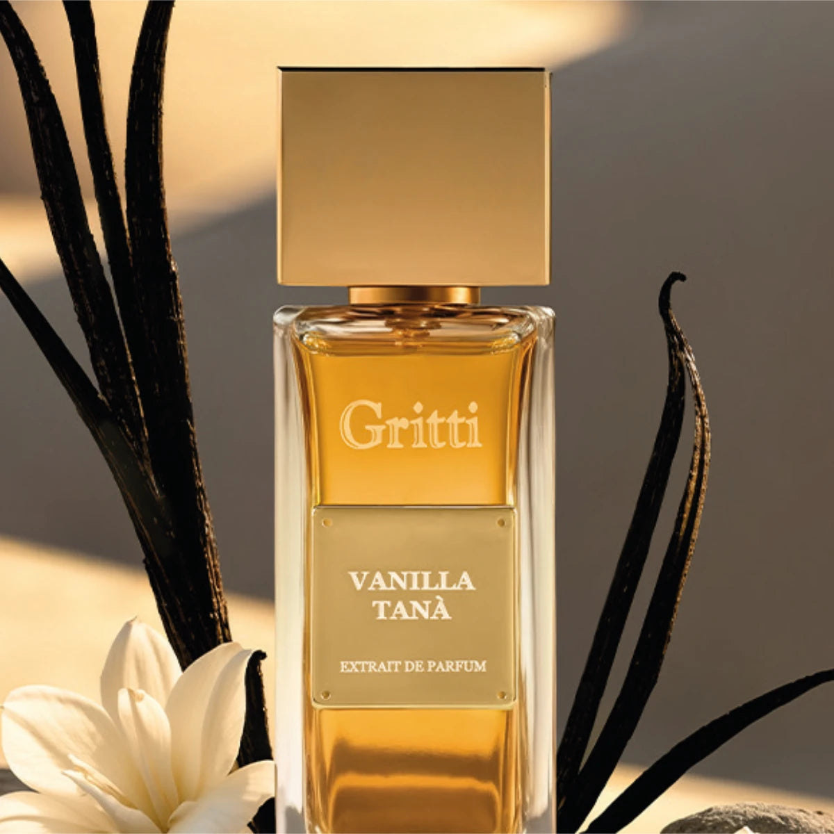 Gritti - Ivy Collection - Vanilla Tanà Parfümflakon mit goldfarbenem Verschluss und Vanilleblüte vor warmem Hintergrund