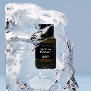 Matière Première - Vanilla Powder - Extrait Parfumflakon elegant in Eisblock eingefroren vor hellblauem Hintergrund