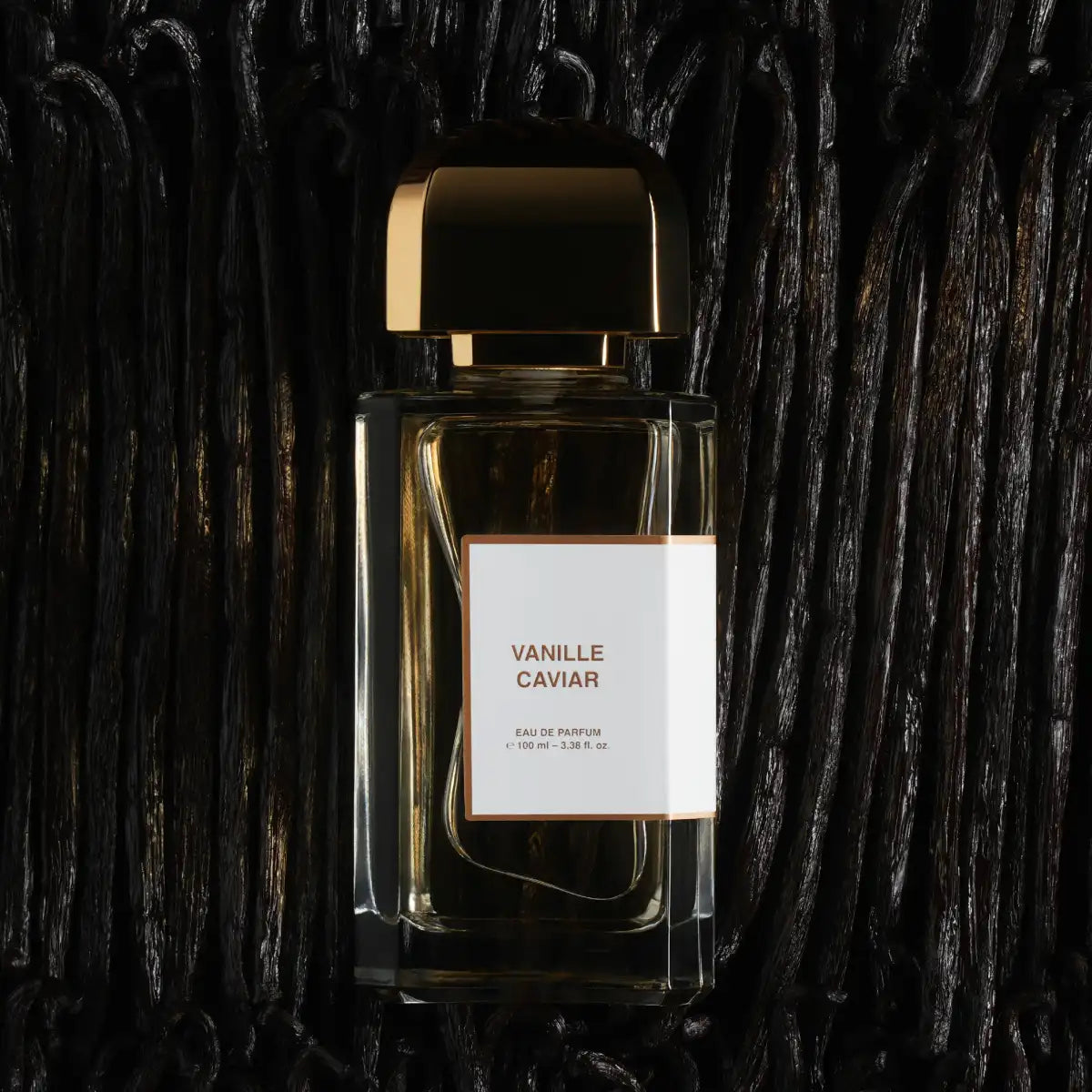 bdk Parfums - Collection Matières - Vanille Caviar Parfumflakon mit goldenem Verschluss vor dunklem Hintergrund
