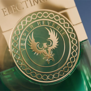 Electimuss - Vesper Reverie Nahaufnahme des goldgrünen Emblems mit elegante Ornamente auf dem Flakonverschluss