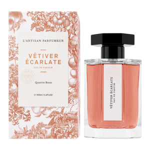 L'Artisan Parfumeur - Le Potager - Vétiver Écarlate Flakon mit lachsfarbenem Duft neben dekorativer Verpackung in floraler Gestaltung