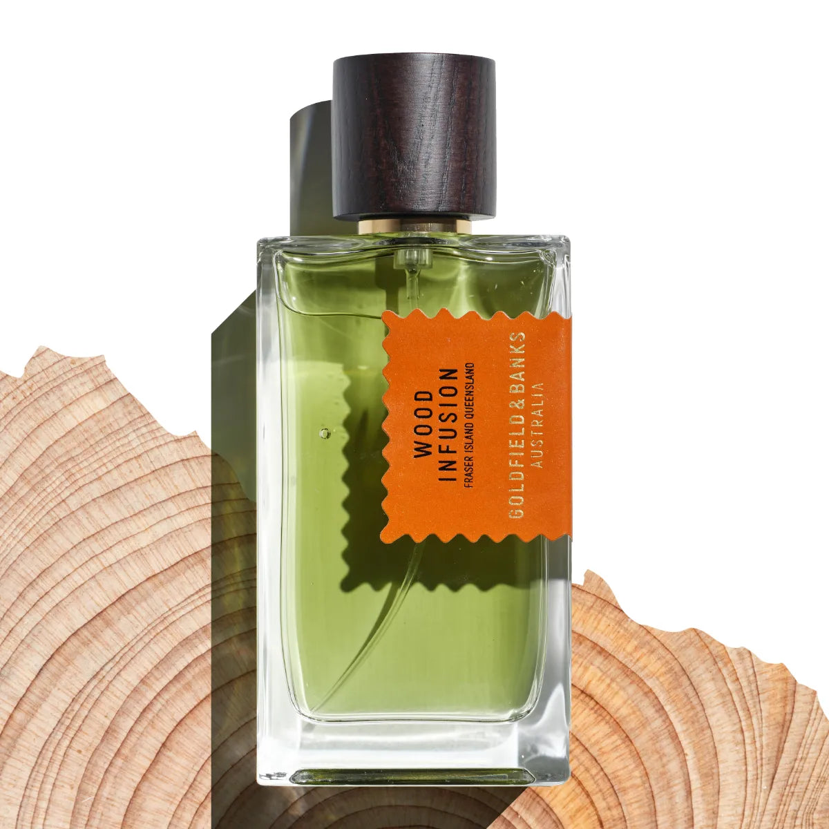 Goldfield & Banks - Native Collection - Wood Infusion Parfumflakon mit grünlicher Flüssigkeit und dunklem Holzverschluss auf Holzscheibe