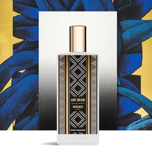 Memo Paris - Abu Dhabi zeigt Flakon mit geometrischem Muster und goldenem Verschluss vor künstlerischem blau-gelb Hintergrund