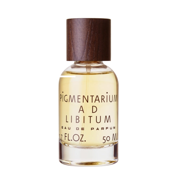 Pigmentarium - Ad Libitum zeigt klaren Parfümflakon mit hellem Duft und naturholzfarbenem Verschluss minimalistisch gestaltet