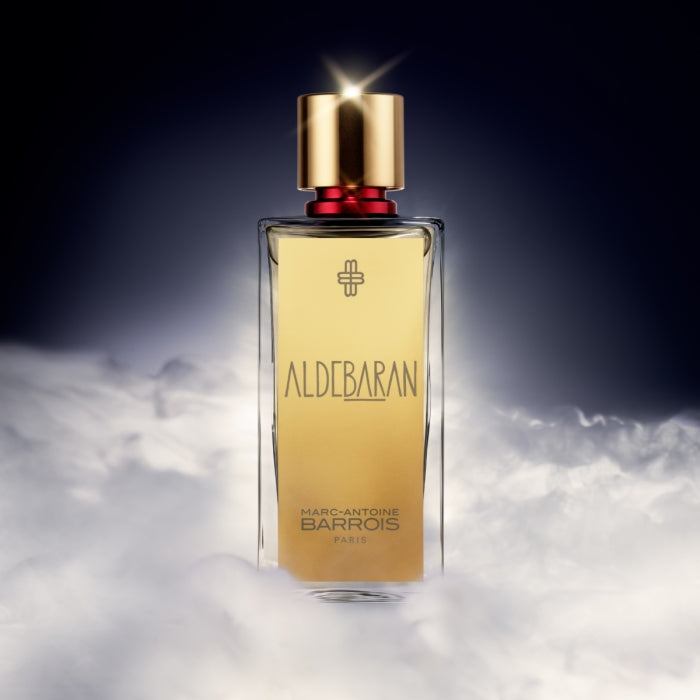 Marc-Antoine Barrois - Aldebaran Parfumflakon mit goldfarbenem Etikett und rotem Verschluss in mystischem Nebellicht