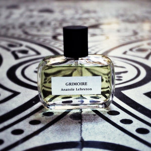 Anatole Lebreton - Grimoire Parfumflakon mit klarem Glas und schwarzem Verschluss auf dekorativem schwarz-weißem Muster