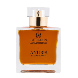 Papillon Perfumery - Anubis Parfümflakon mit bernsteinfarbener Flüssigkeit und transparentem, goldfarbenem Verschluss vor weißem Hintergrund