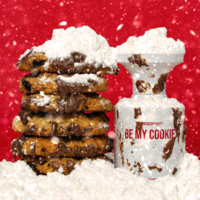 BORNTOSTANDOUT - Be my Cookie Parfumflakon mit schokoladigem Design und pudrigem Schneeeffekt vor rotem Hintergrund