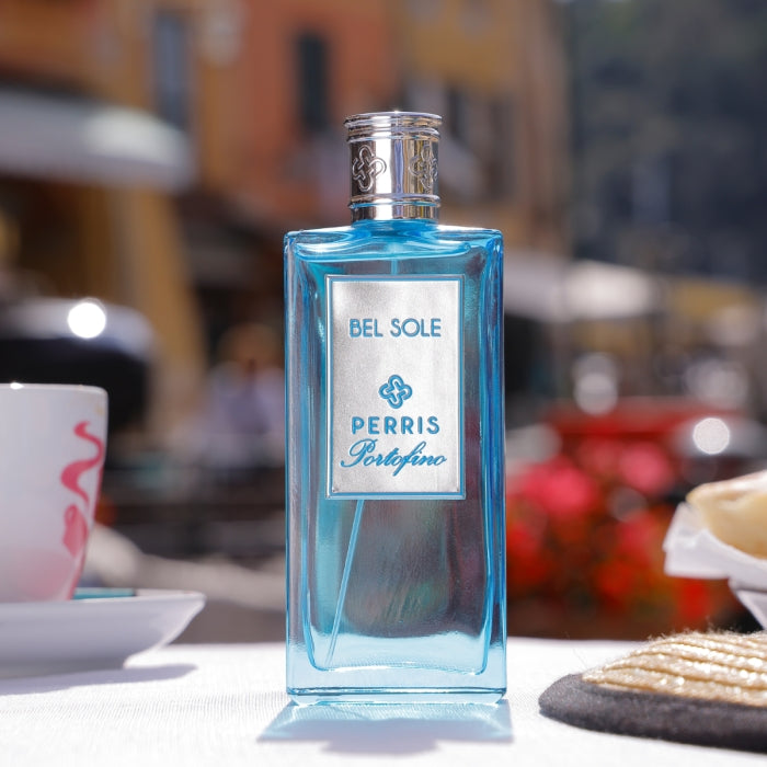Perris Monte Carlo - Portofino - Bel Sole blauer Flakon mit silbernem Verschluss vor sonniger mediterraner Kulisse