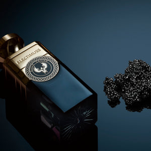 Electimuss - Black Caviar Flakon mit goldenem Verschluss und tiefblauem Glas vor schwarzem Kaviar auf dunklem Hintergrund