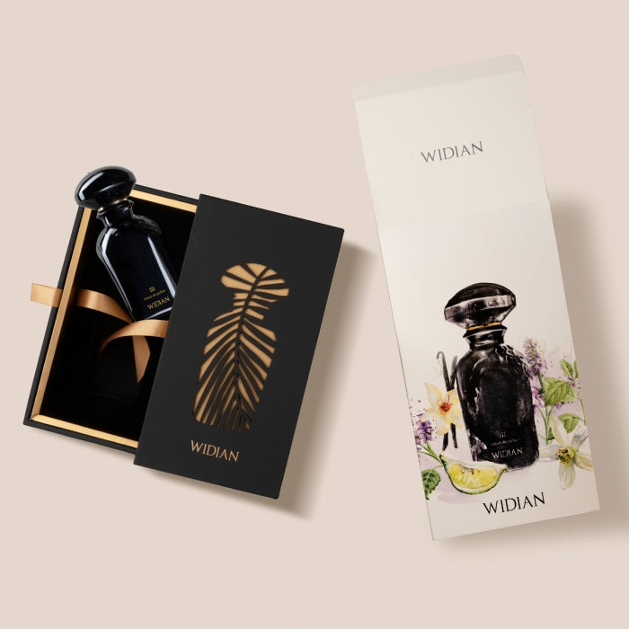 Widian - Black Collection - Black III eleganter schwarzer Flakon mit goldener Geschenkbox und floraler Verpackung auf hellem Hintergrund