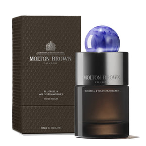 Molton Brown - Bluebell & Wild Strawberry zeigt eleganten Flakon mit dunkel getöntem Glas und blauer Kugelkappe neben Verpackung