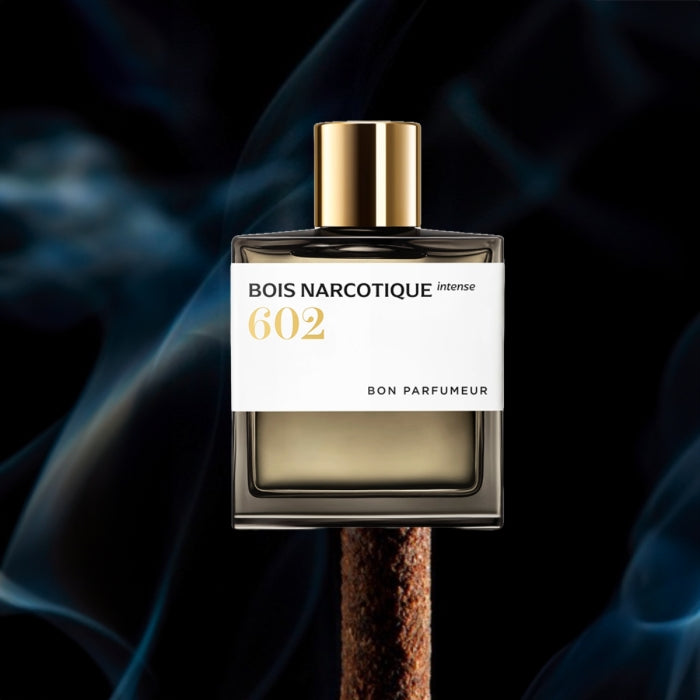 Bon Parfumeur - Les Extraits - 602 Bois Narcotique Intense Parfumflakon mit goldfarbenem Verschluss vor dunklem Rauchhintergrund
