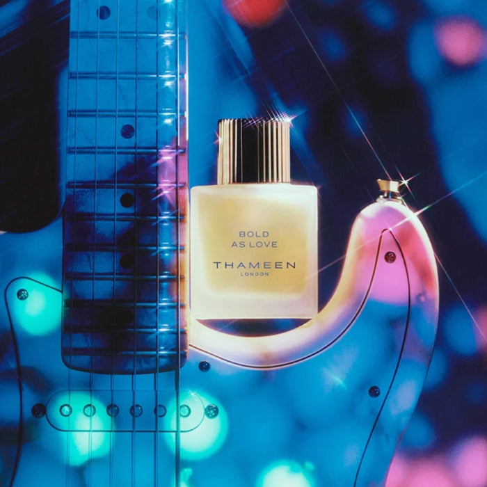 Thameen - Britologne Collection - Bold as Love Parfümflakon mit goldfarbenem Verschluss vor beleuchteter E-Gitarre