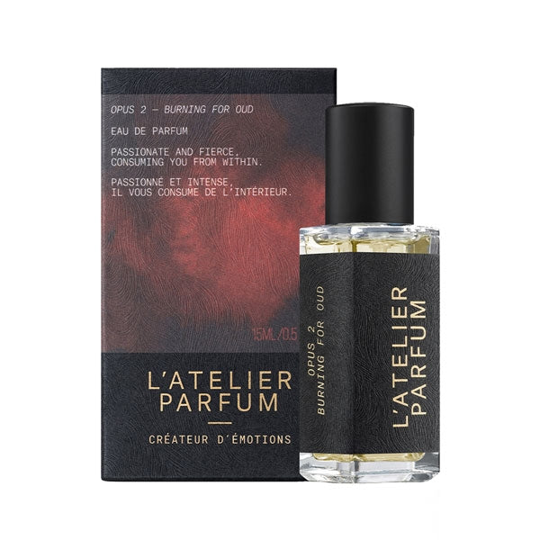 L'Atelier Parfum - Opus 2 - Burning for Oud Flakon mit schwarzem Lederetikett vor dunkler, roter Verpackung
