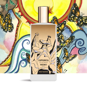 Memo Paris - Cappadocia Parfumflakon mit surrealistischem Design vor farbenfrohem Hintergrund mit Schmetterlingen