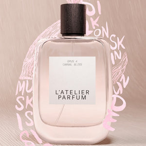 L'Atelier Parfum - Opus 4 - Carnal Bliss Flakon mit klarem Glas und dunkelbraunem Holzverschluss vor beigem Hintergrund